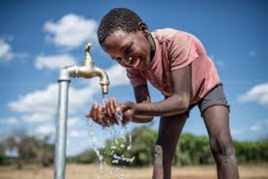 Petit garçcon entrain de boire l'eau au robinet